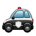 Маленький полицейский автомобиль в мультяшном стиле с белой крышей и черным кузовом, на боковой двери которого изображен белый щит, а на крыше установлена красная мигалка.